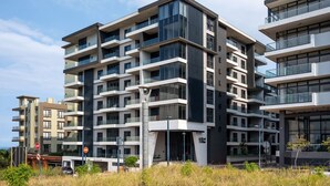 Un edificio residencial de varios pisos con balcones, grandes ventanales y un diseño arquitectónico moderno.