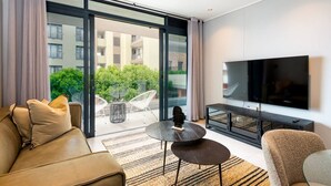 Una sala moderna con sofá, mesa de centro y televisor.