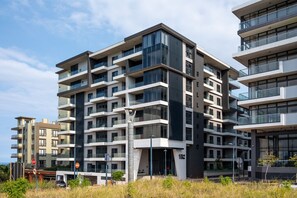 A multi-story residential building with balconies, a stop sign, and a clear sky. - Stunning 204 Bellagio on Umhlanga Ridge (uMhlanga)