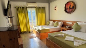 Habitación de hotel con dos camas, un cabecero de madera, una mesita pequeña, un teléfono y una obra de arte colgada en la pared.