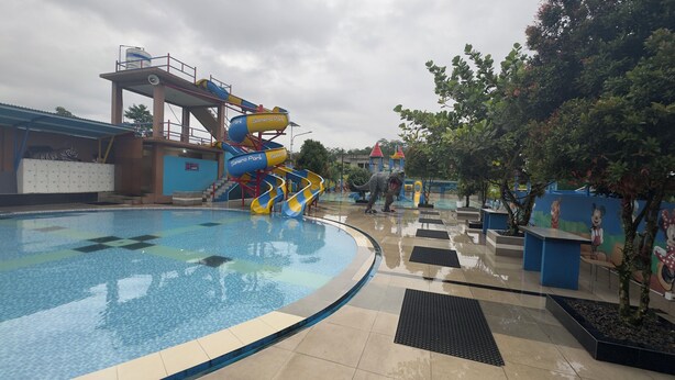 A water park with a large pool, a water slide, and dinosaur statues. - SANERA Villa by SATYA Hospitality (Wonosobo)
