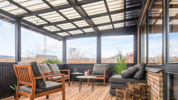 A covered outdoor seating area with wooden furniture and a view of the surrounding landscape. - 4 Star Holiday Home in Viborg (Viborg)
