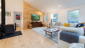 Una sala de estar con chimenea, un sofá, una mesa de centro y un televisor.