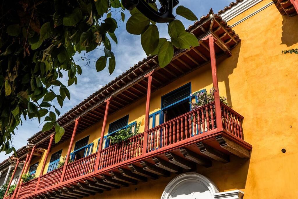 A yellow building with red balconies and blue window frames.