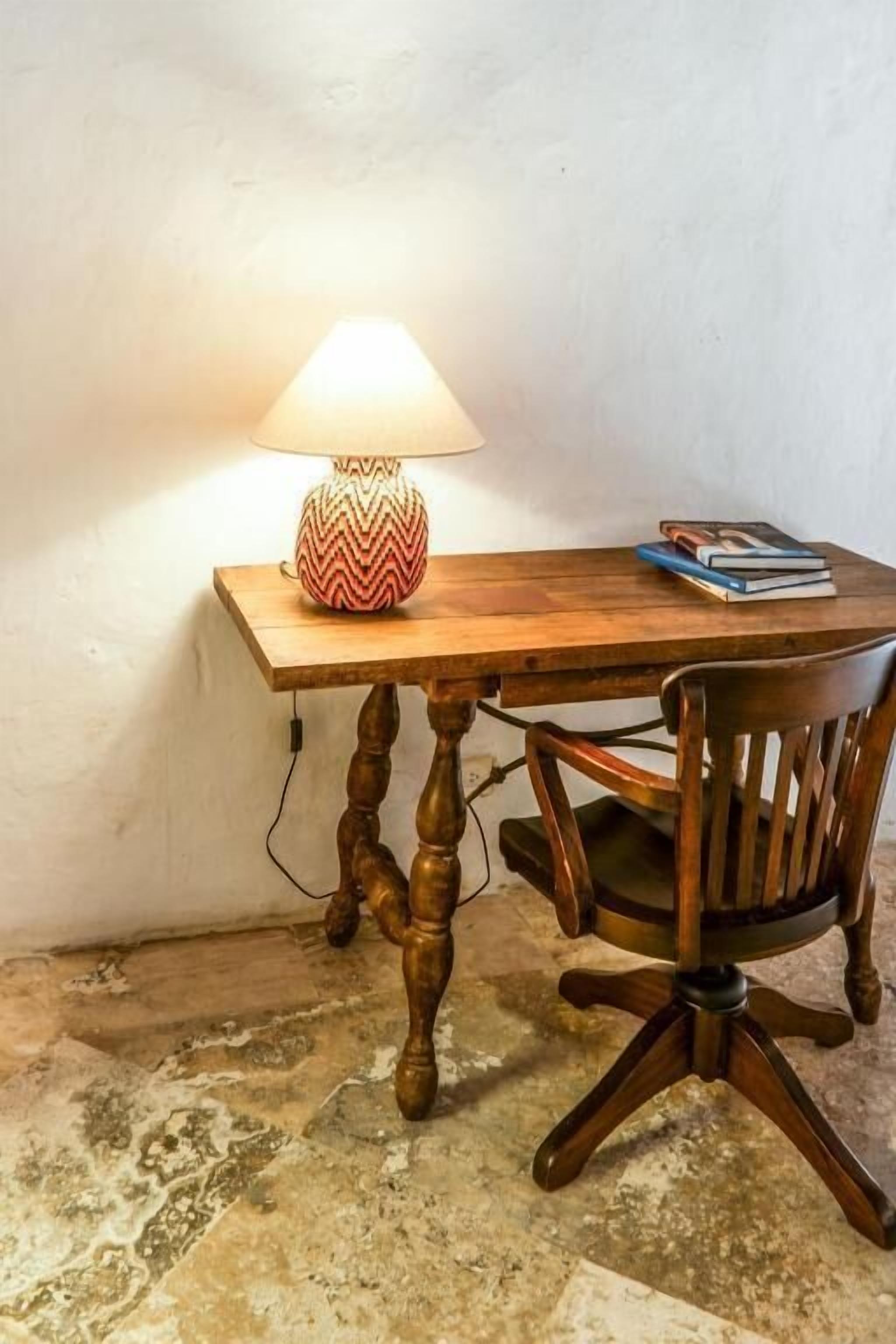 Ein Holztisch mit einer Lampe und einem Stuhl.