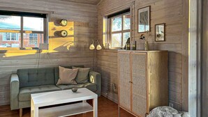 A cozy room with a sofa, a small table, a cabinet, and a window with curtains. - Beautiful home in Vordingborg with WiFi (Vordingborg)