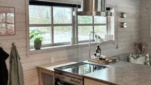 A kitchen with a stove, oven, and a window with a view of trees. - Beautiful home in Vordingborg with WiFi (Vordingborg)
