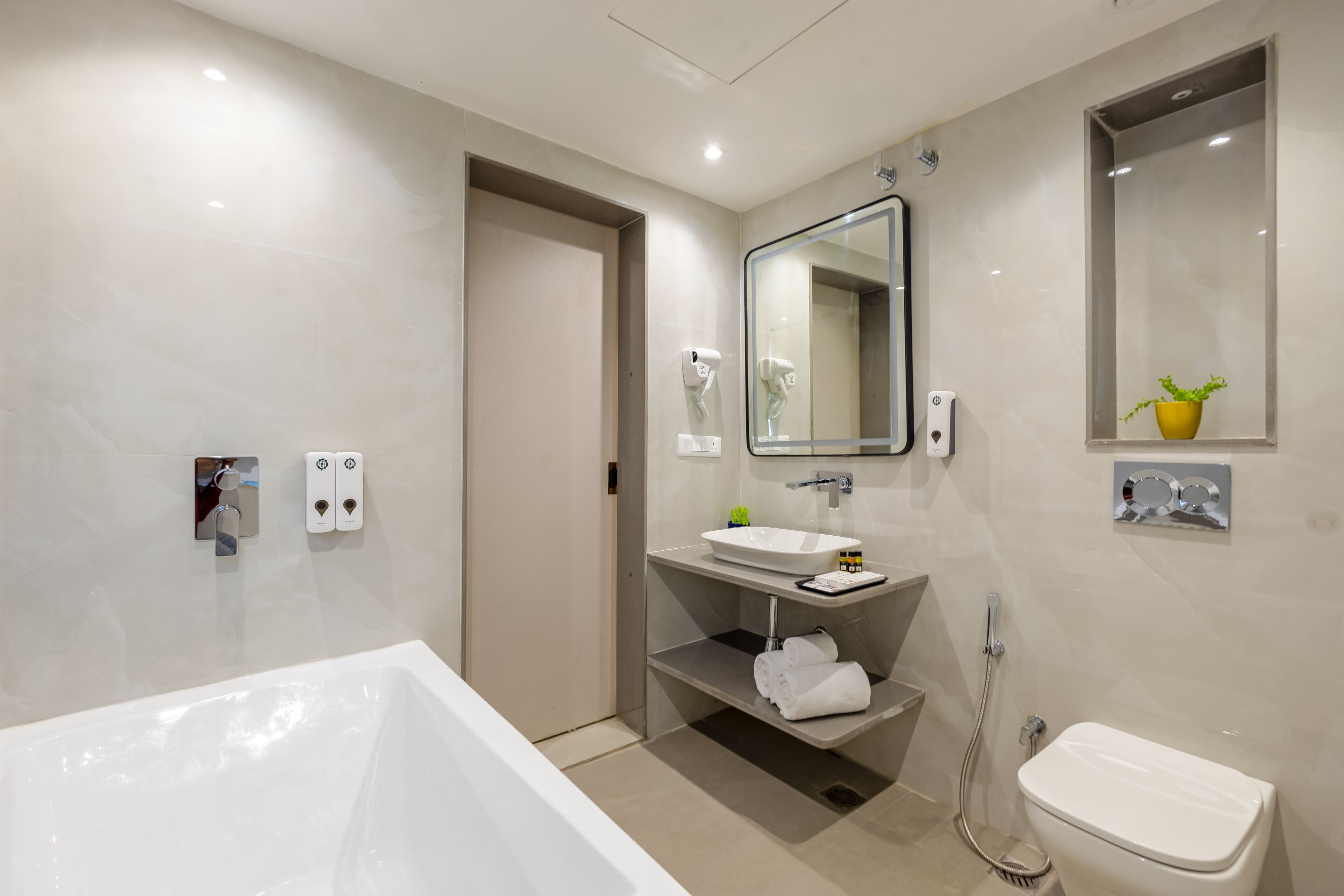 A modern bathroom with a bathtub, sink, and toilet.