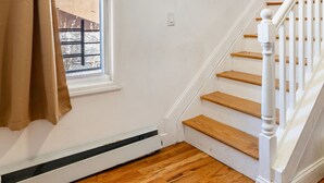 Una escalera con barandillas blancas y escalones de madera que conducen a una plataforma.