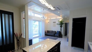 Un salon moderne avec une grande fenêtre, un canapé, une table basse et une plante décorative.