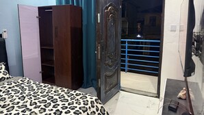 Ein Schlafzimmer mit Bett, Kleiderschrank und einer Tür zum Balkon.
