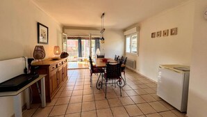 A kitchen with a dining table, chairs, a bench, a refrigerator, and a window. - House for 6 guests with air conditioning and Wi-Fi – Hyères Port (HYERES)