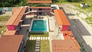 Un resort con piscina, varias edificaciones y zona de playa.