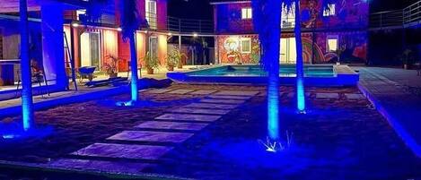 Una piscina al aire libre, sombrillas, sillones reclinables de piscina