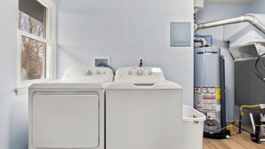 A laundry room with two stacked front-loading washers and a large water heater. - Home Suite Home: E-Minutes to Downtown & P Heights (Peoria)