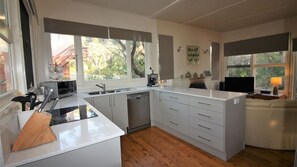 A modern kitchen with a central island, built-in appliances, and a view of the outdoors. - Green Island Escape near Green Island (Cunjurong Point)