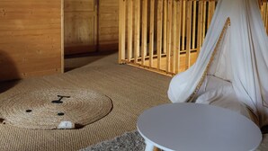 Una stanza accogliente con soffitto in legno, una sedia a dondolo e un piccolo tavolino rotondo.