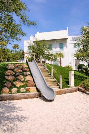 A white building with a wooden staircase and a gray slide. - Lotus by the Sea Seacrest 30A FL Pool, Beach Tram (Rosemary Beach)