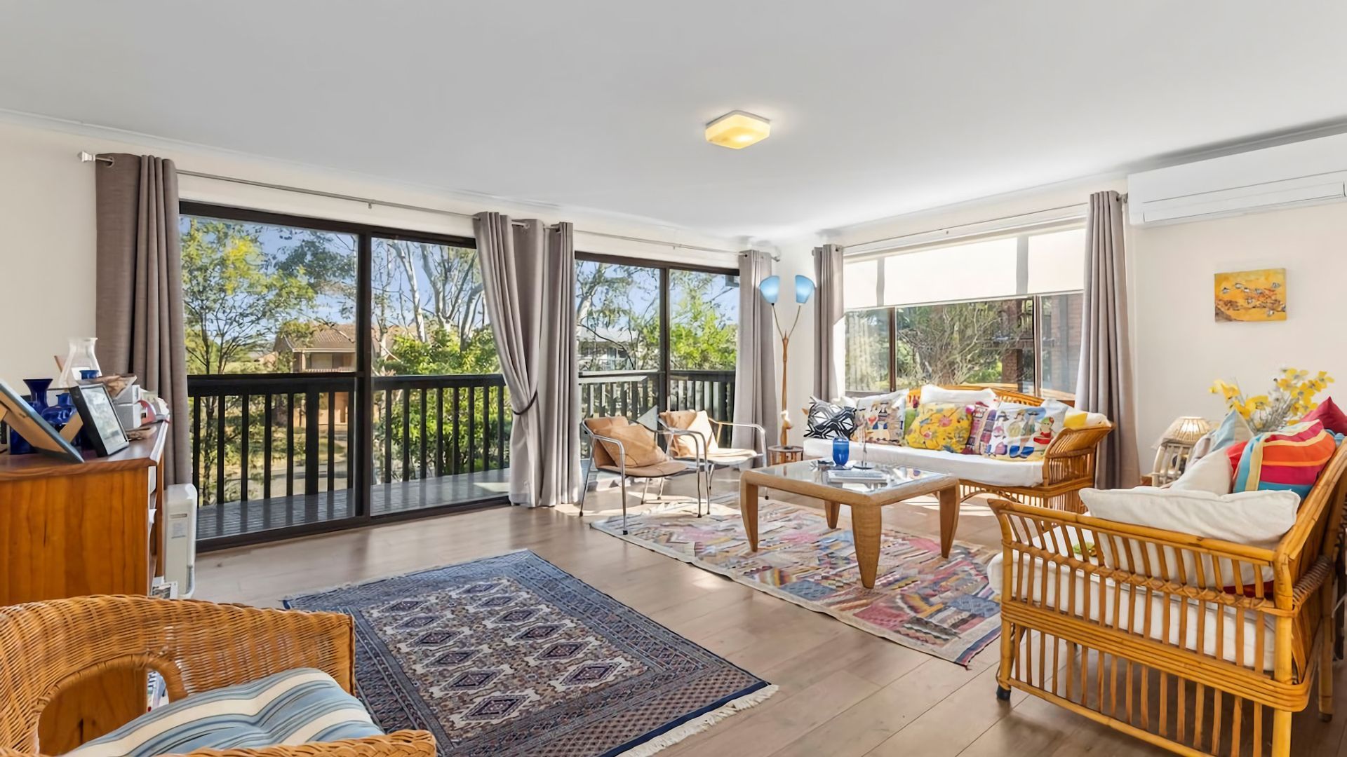 A spacious living area with a balcony, a dining table, and comfortable seating.