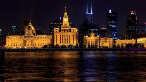 Un bâtiment historique doté d’une tour horlogée, dont le reflet se mire dans l’eau.