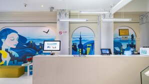 Un espace d’accueil comprenant un écran d’ordinateur, un certificat encadré et un panneau indiquant qu’il est interdit de fumer.