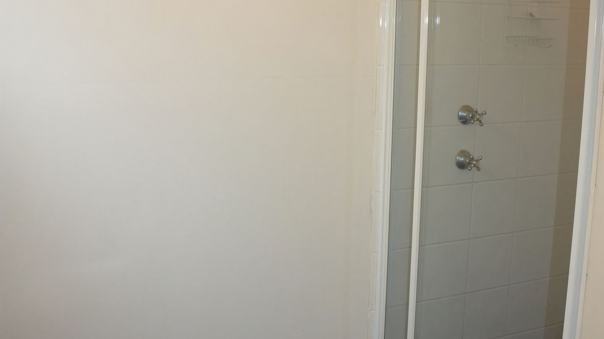 Ein Badezimmer mit Duschbereich, Toilette und Waschbecken.