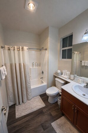 A bathroom with a bathtub, toilet, and sink, featuring a shower curtain, a window, and a mirror. - Stay Demo 1BA Hideaway In Marina Del Rey (Marina del Rey)