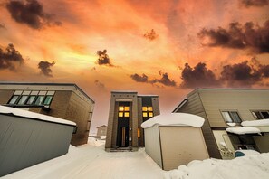 Een gebouw met een bakstenen gevel en een grote hoofdingang, omgeven door sneeuw.