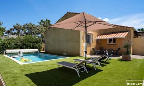 Un giardino con piscina, una veranda coperta e mobili da esterno.