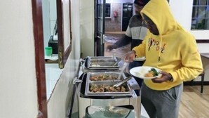 A buffet setup with various food items and utensils. - Goshen Farm Hotel (Kiriaini)