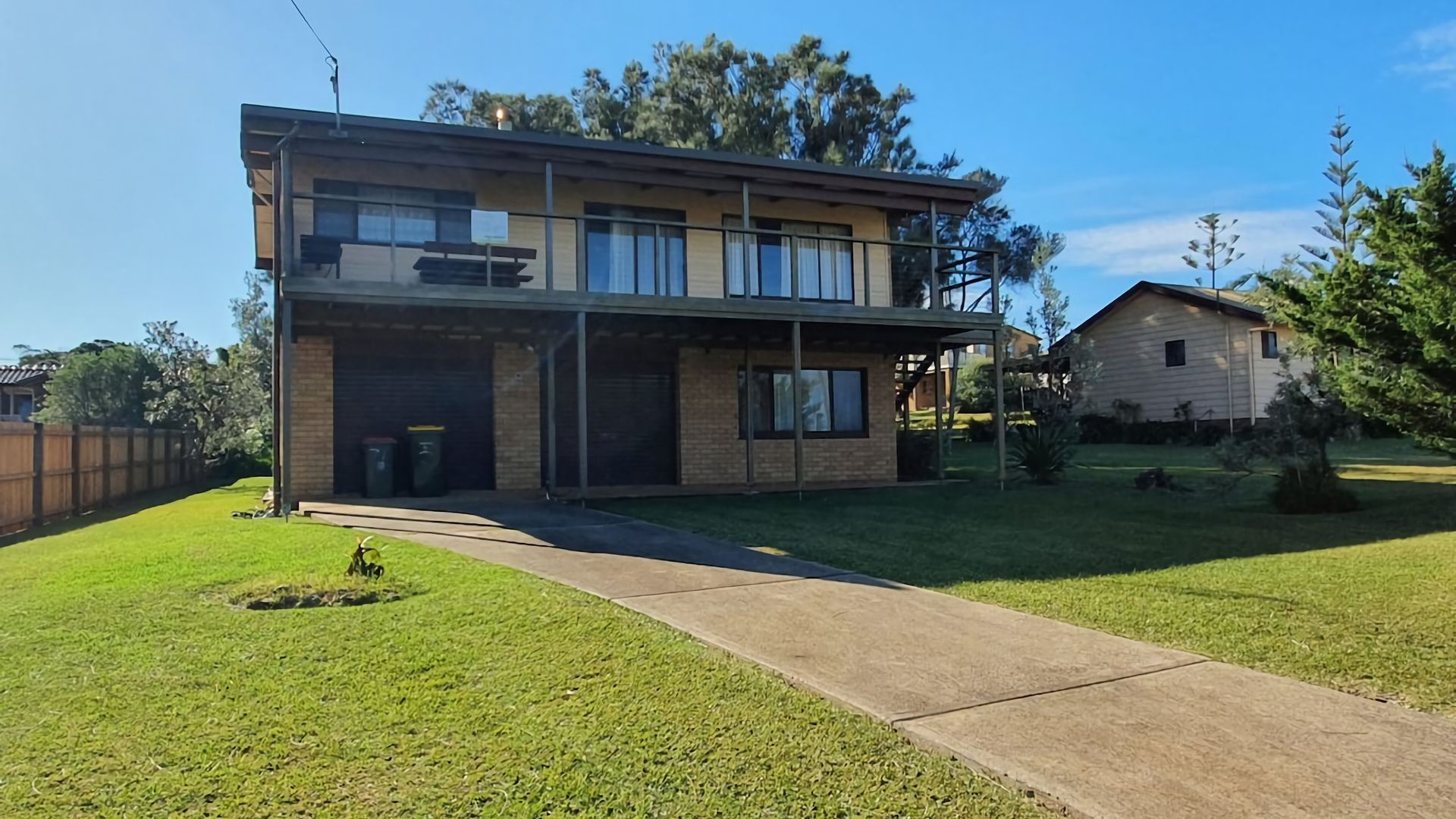 Ein zweistöckiges Haus mit Garage, überdachter Terrasse und gepflegtem Rasen.