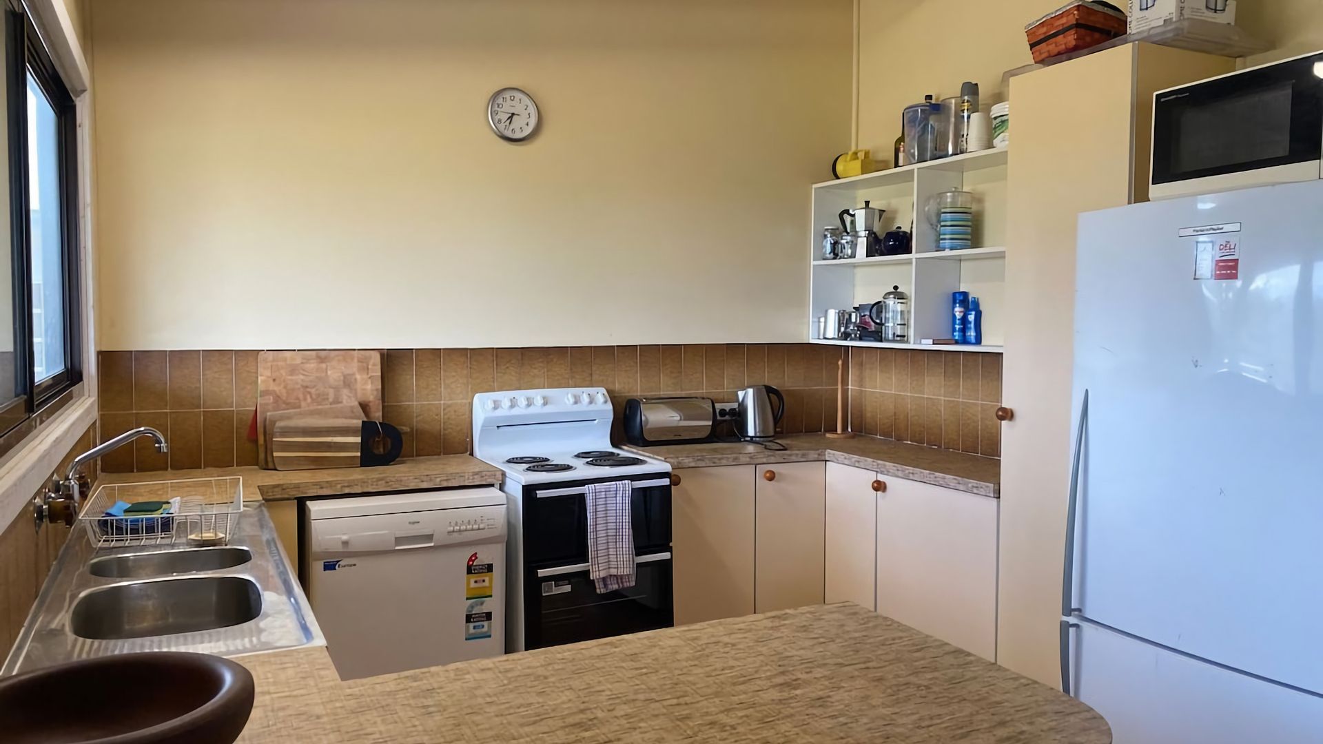 A compact kitchen with a stove, sink, and refrigerator.