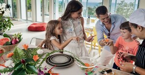 A family dining at a table with a view of the outdoors. - Surin Beach Seaview Luxury Villa with Pool (Tambon Choeng Thale)