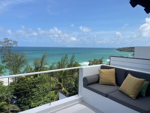 A balcony with a view of the ocean and a seating area with cushions. - Surin Beach Seaview Luxury Villa with Pool (Tambon Choeng Thale)