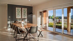 Un coin repas comprenant une table en bois, quatre chaises et deux reproductions botaniques encadrées accrochées au mur.