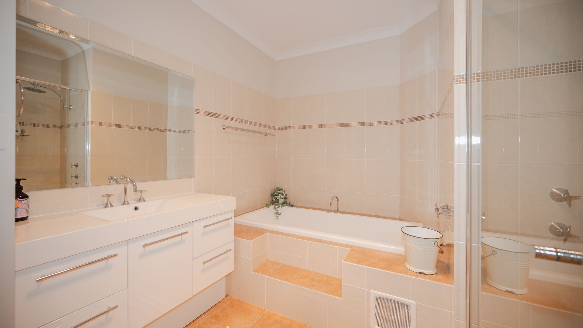Un bagno moderno con un lavabo doppio, una vasca da bagno e un box doccia.