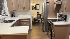 Una cocina moderna con armarios de madera, electrodomésticos de acero inoxidable y una isla central.