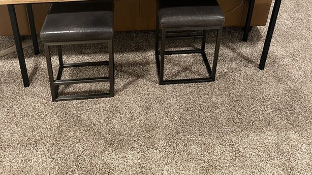 Una sala moderna con sofá, televisor y chimenea. Dos lámparas a cada lado de una mesa de centro de madera.