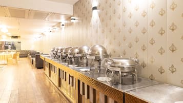 A buffet setup with multiple serving stations, a long counter, and a patterned wall.