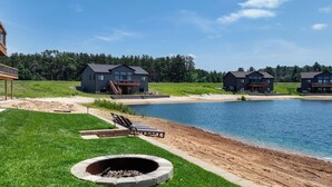 Propiedad junto al lago con fogata, sillas de descanso y zona para nadar.