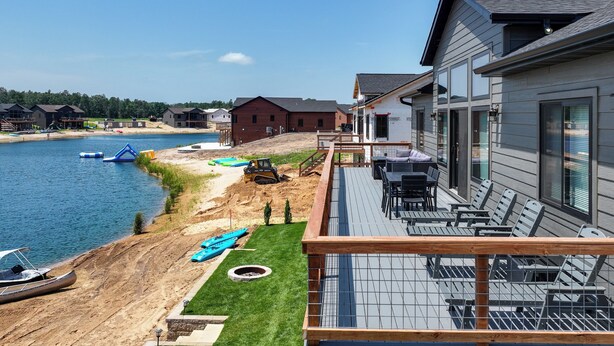 Una propiedad frente al agua con terraza, asientos exteriores y vistas al agua.