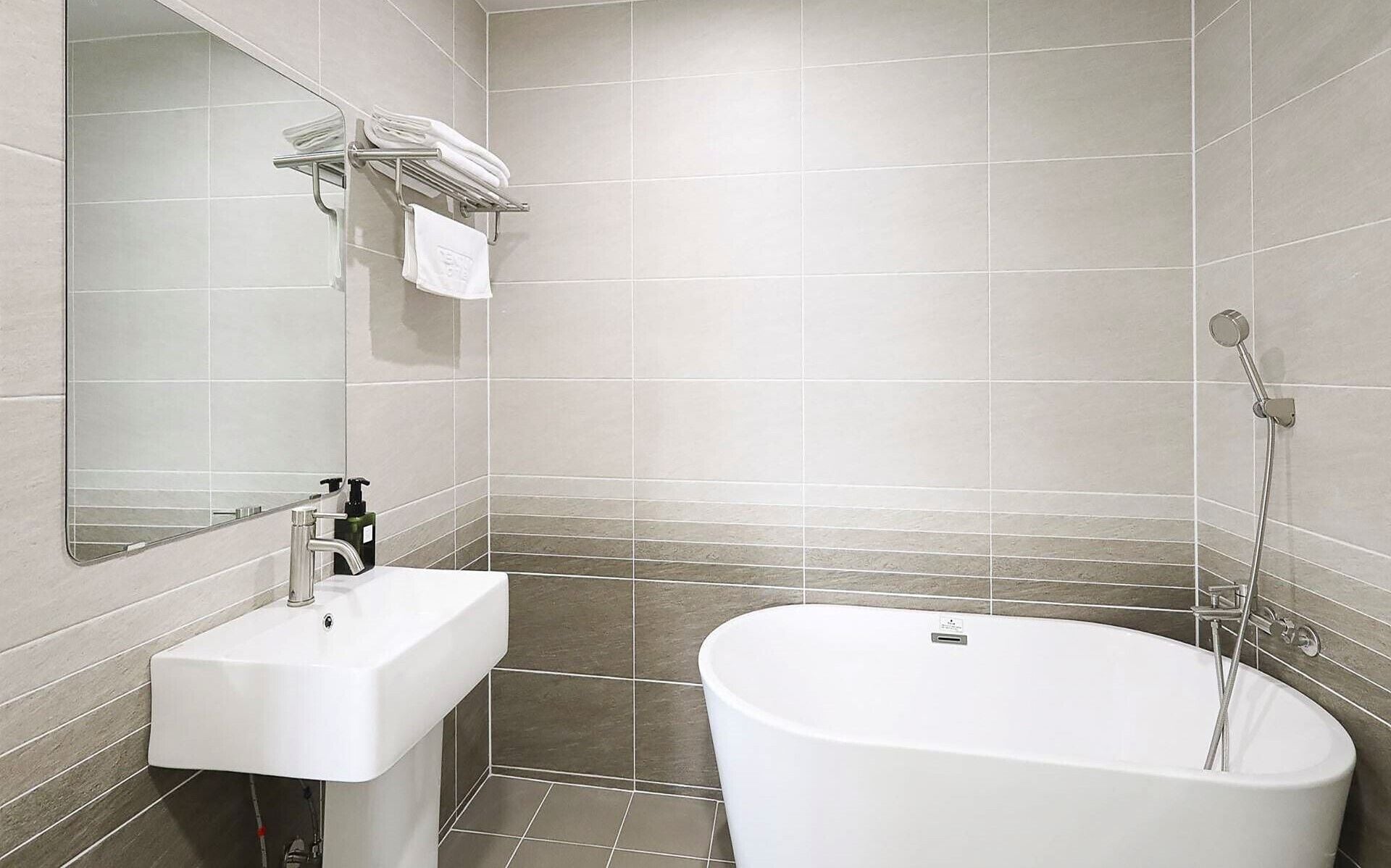 Een moderne badkamer met een vrijstaand bad, een wastafel en een spiegel.