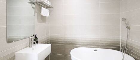 A modern bathroom with a freestanding bathtub, a sink, and a mirror.
