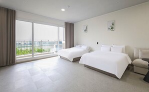 Ett hotellrum med två sängar, ett stort fönster med utsikt och en balkong.
