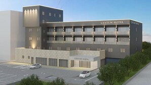 Un moderno edificio de hotel con techo plano, varios balcones y un estacionamiento con dos coches.