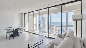 Ein modernes Hotelzimmer mit großem Balkon, einer Essecke und einer Couch.
