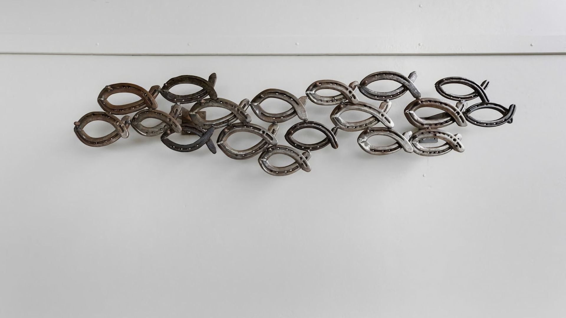 A collection of metal horseshoes arranged on a flat surface.