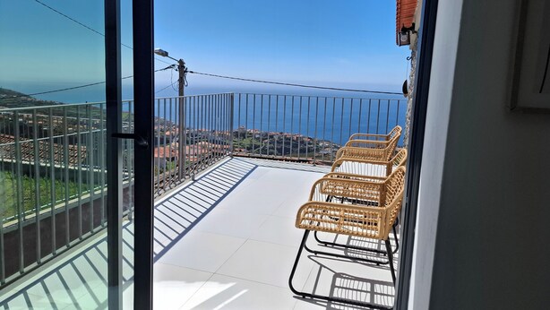 A balcony with a view of the sea, a railing, and wicker chairs. - family and groups escape with  views , sunrise and sunsets in a quiet corner  (Calheta)