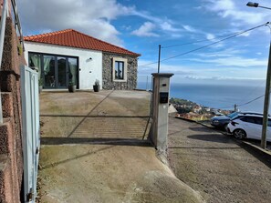 Ein Wohnhaus mit Steinverkleidung, einem roten Ziegeldach und Meerblick.