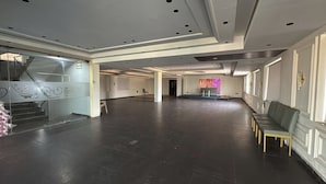 A spacious lobby with a staircase, a reception area, and a seating area. - Hotel SN Grand (Maheshwaram)